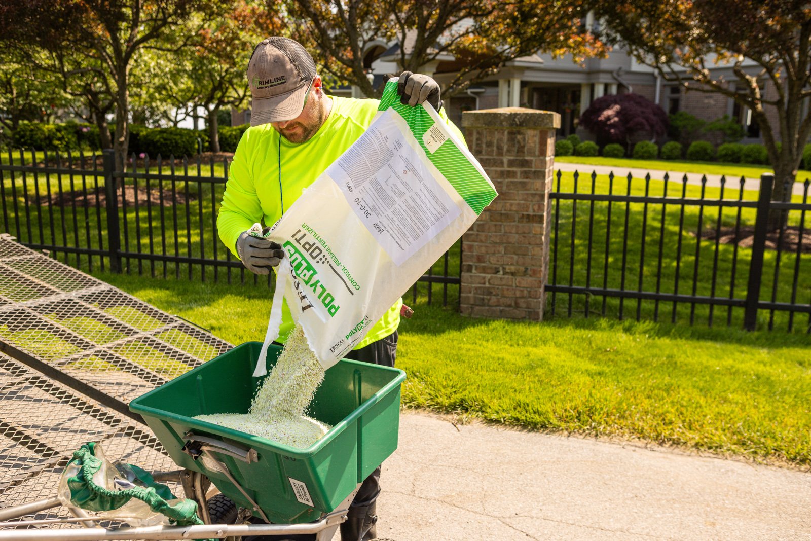 lawn care tech adjusting fertilizer for rochester's conditions