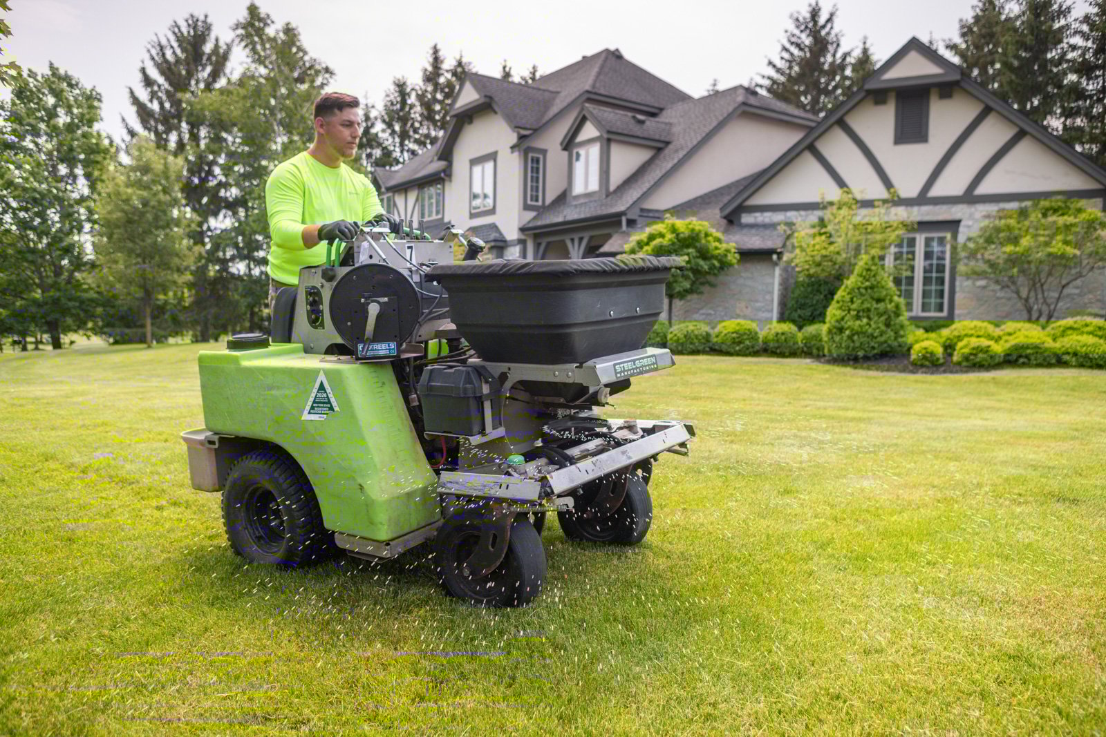 applying granular fertilizer to boost spring lawn health