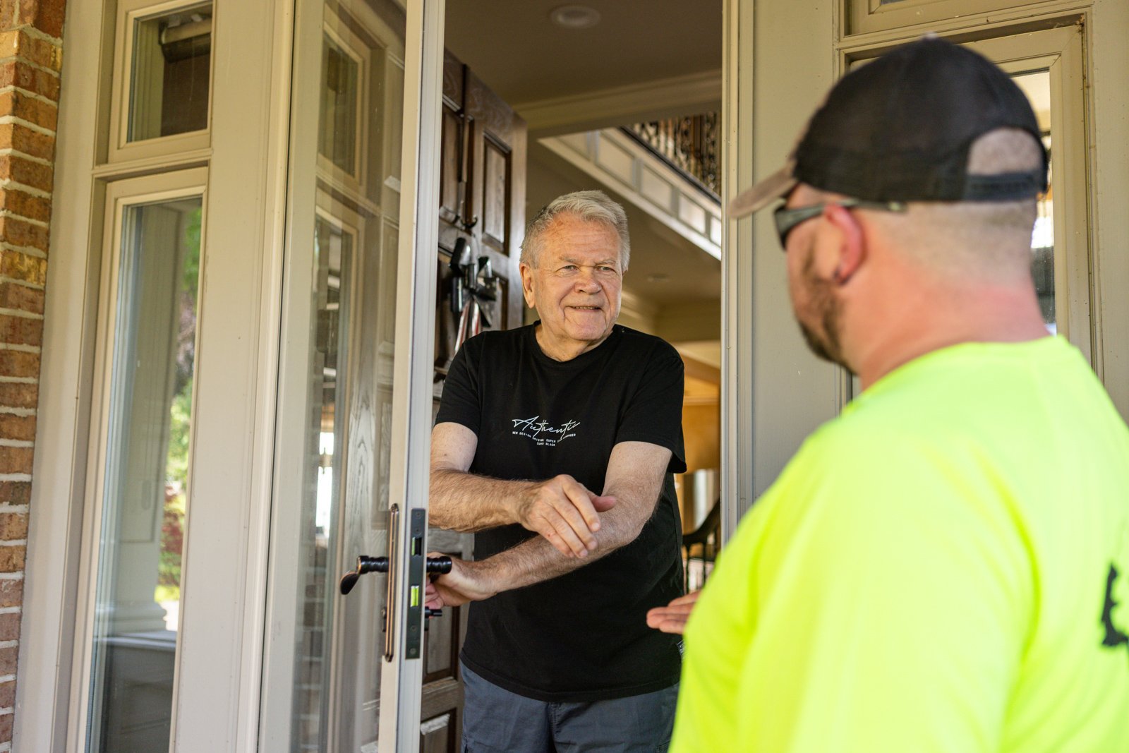 Rochester homeowner meeting with a lawn care tech